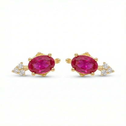 Paires de puces d'oreilles dorées serties d'une pierre centrale rouge (style rubis) taille ovale et d'un trio de petits zircons latéraux