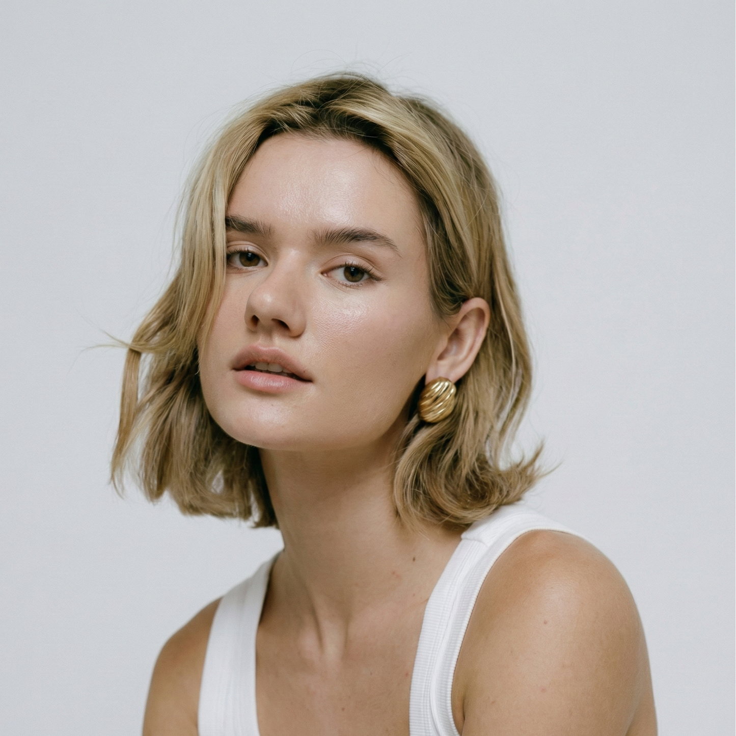 Boucles d'oreilles puces motif coquillage strié en acier inoxydable doré, l'accessoire indispensable tendance sirène (mermaidcore) pour l'été.