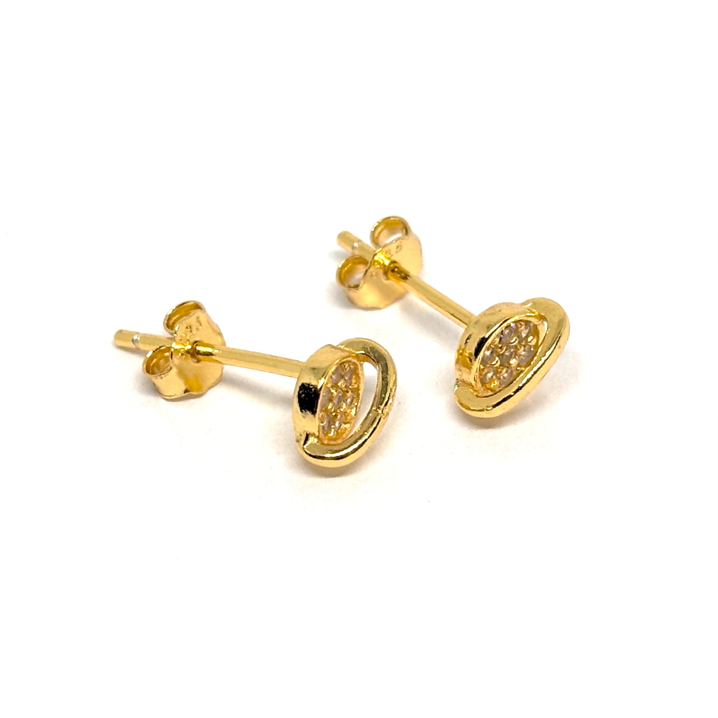 Boucles d’oreilles puces femme en argent 925 doré à l’or 18k représentant la planète Saturne sertie de zircons scintillants. Bijou céleste et minimaliste inspiré de l’univers, symbole d’équilibre et de mystère cosmique. Design fin et lumineux avec anneau doré et cœur brillant, parfait pour un look moderne, spirituel ou poétique. Accessoire léger, résistant à l’oxydation, idéal pour un port quotidien ou un cadeau symbolique.