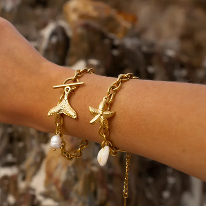 Bracelet femme doré orné de breloques marines : étoile de mer, coquillage cauri naturel et petite coquille dorée. Bijou fantaisie estival, lumineux et bohème chic, avec finition brillante et longueur ajustable, parfait pour un look bord de mer élégant