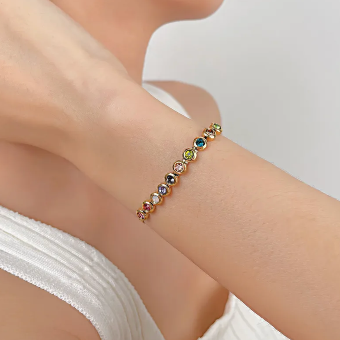 Bracelet femme doré en acier inoxydable plaqué or 18K, orné de 9 cristaux multicolores sertis sur une chaîne fluide. Bijou tendance, coloré et raffiné, hypoallergénique et résistant à l’eau, idéal pour un look lumineux et joyeux