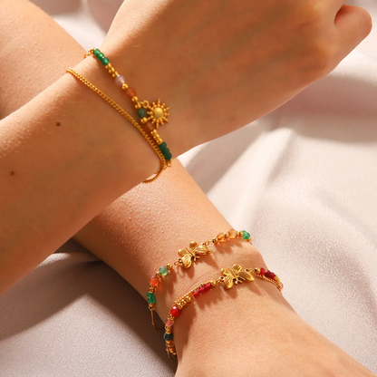 Bracelet femme doré en acier inoxydable, orné d’un papillon central et de perles colorées. Bijou bohème chic et estival, hypoallergénique, résistant à l’eau et lumineux, idéal pour un look romantique et plein de peps