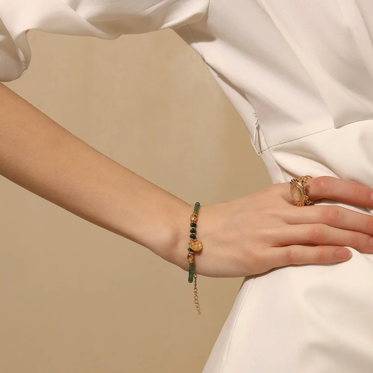 Bracelet femme en acier inoxydable doré 18K, orné de perles vertes effet malachite et d’un pendentif rond martelé. Bijou élégant, ajustable et lumineux, inspiré de la nature, alliant sophistication dorée et énergie mystique