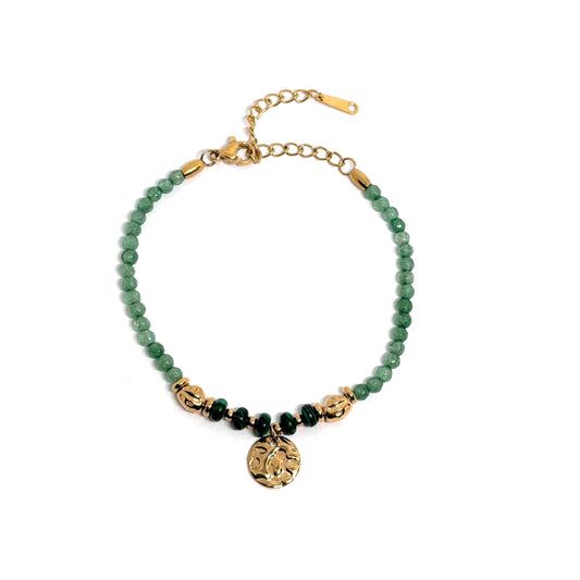 Bracelet femme en acier inoxydable doré 18K, orné de perles vertes effet malachite et d’un pendentif rond martelé. Bijou élégant, ajustable et lumineux, inspiré de la nature, alliant sophistication dorée et énergie mystique