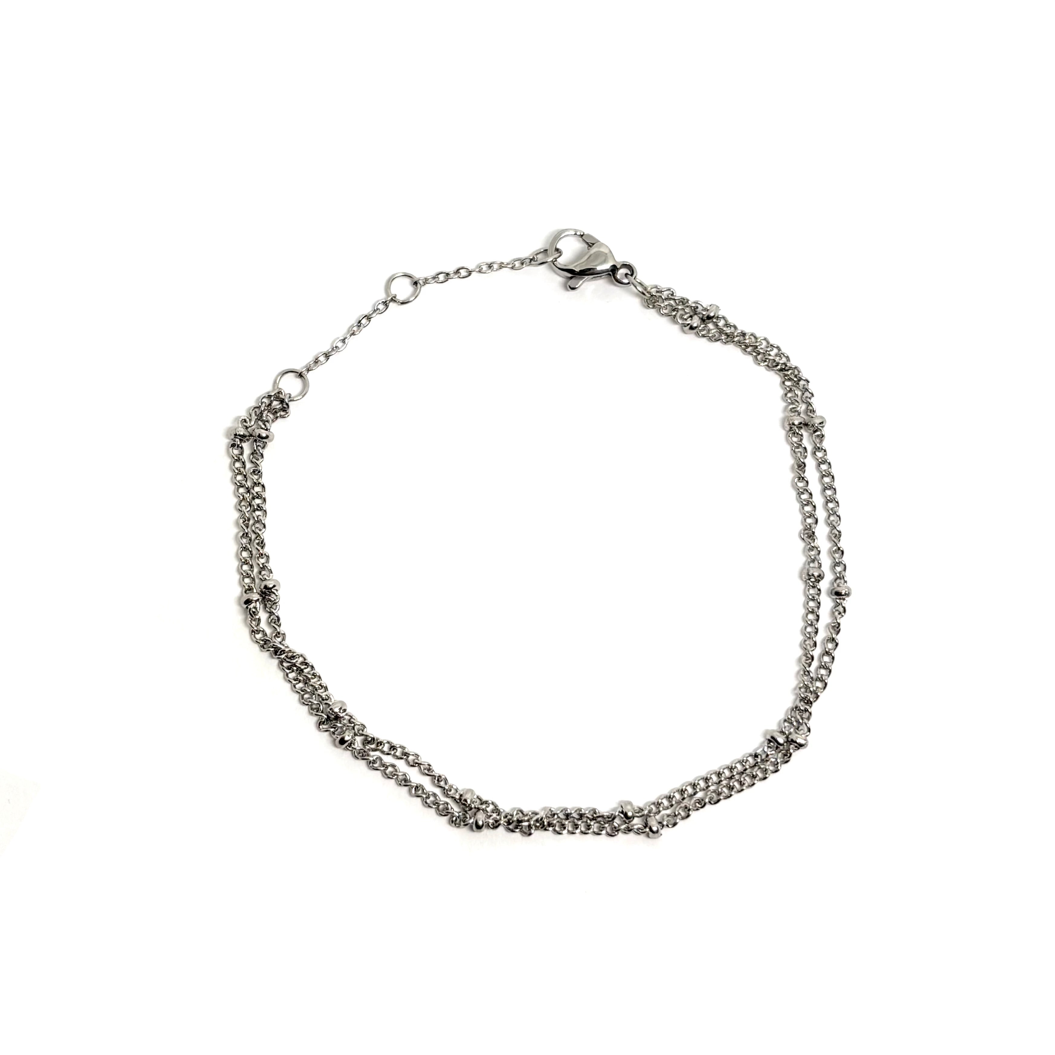Bracelet femme en acier inoxydable couleur argent, composé de deux chaînes perlées entrelacées. Bijou fin, élégant et durable, résistant à l’eau, hypoallergénique et ajustable, parfait pour un look minimaliste chic au quotidien.