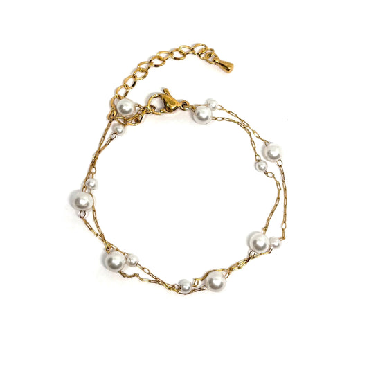 Bracelet femme double rang en acier inoxydable couleur or, orné de perles blanches de tailles variées. Bijou élégant et minimaliste, ajustable, léger et raffiné, parfait pour un look féminin et sophistiqué au quotidien ou en soirée