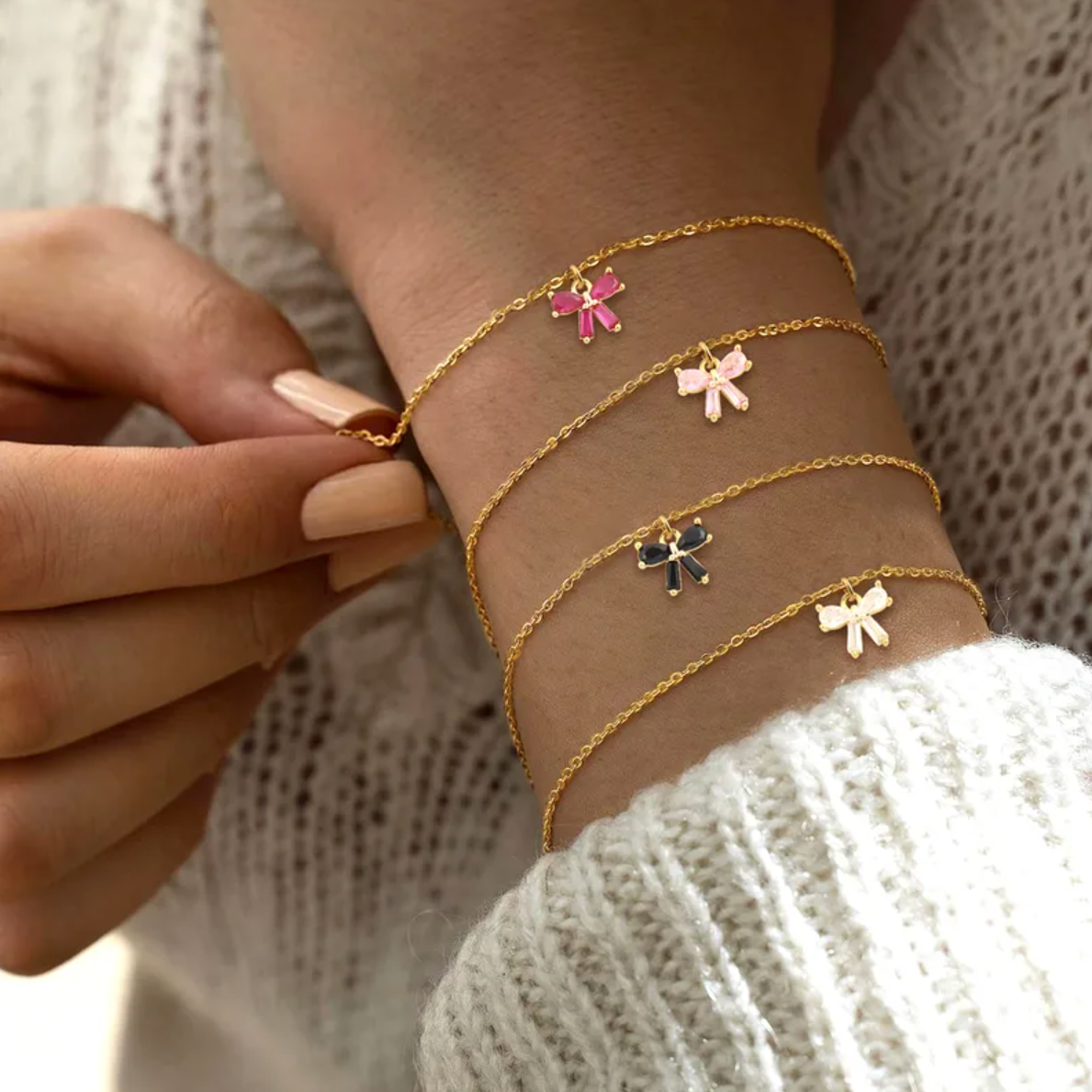 Bracelet femme en acier inoxydable couleur doré, orné d’un petit nœud serti de pierres roses façon grenat. Bijou fin, romantique et ajustable, hypoallergénique et résistant à l’eau, parfait pour un look féminin et raffiné