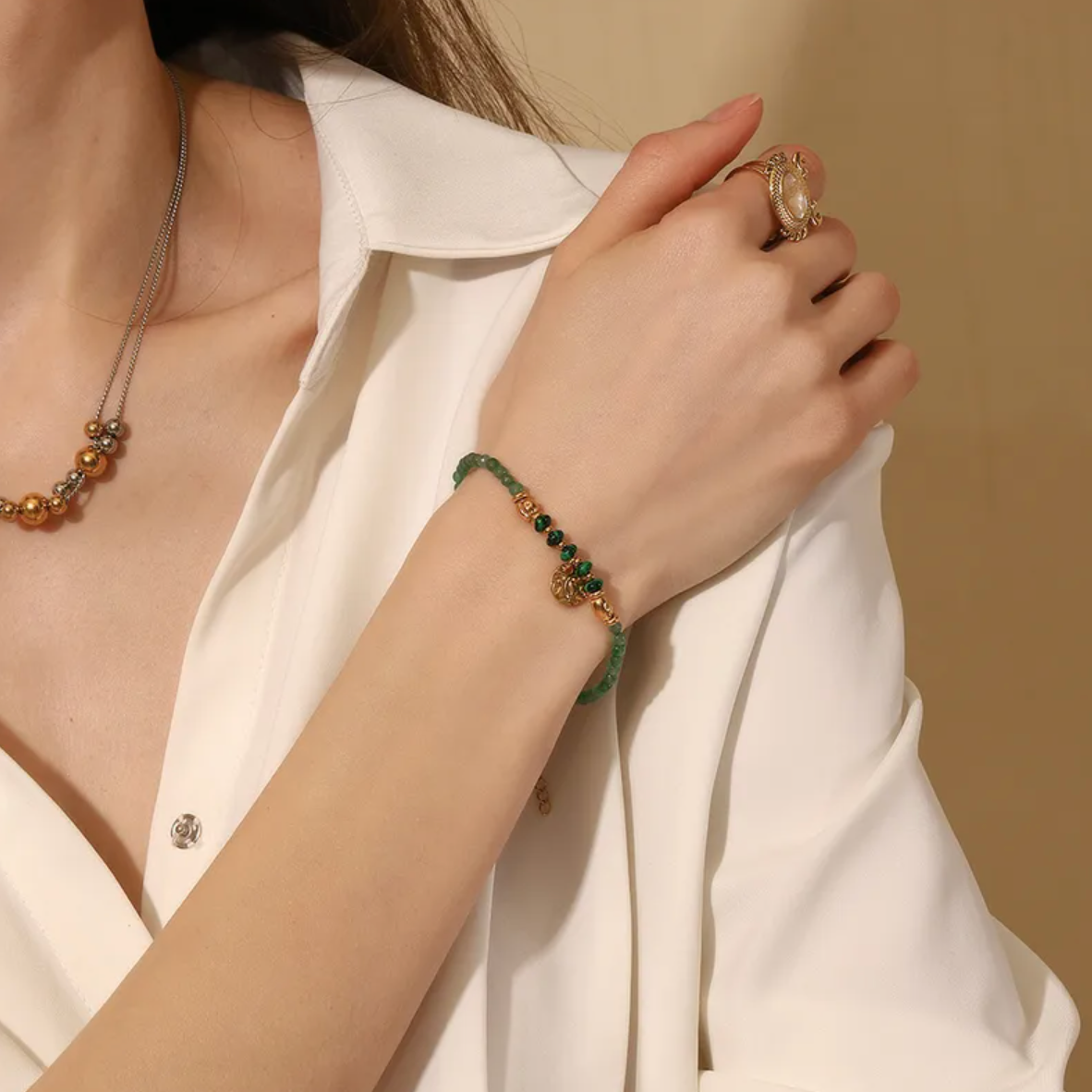 Équilibre parfait entre inspiration naturelle et élégance dorée, ce bracelet en pierre verte type malachite offre une touche mystique et féminine. Le pendentif rond martelé, suspendu au centre, capte la lumière et accentue l’énergie organique du bijou.

Les perles vert profond strié effet malachite évoquent l’ancrage et la stabilité, tandis que les finitions couleur or assurent un rendu sophistiqué et lumineux. Un bijou idéal pour les esprits libres et raffinés.