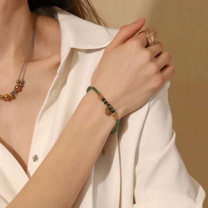 Équilibre parfait entre inspiration naturelle et élégance dorée, ce bracelet en pierre verte type malachite offre une touche mystique et féminine. Le pendentif rond martelé, suspendu au centre, capte la lumière et accentue l’énergie organique du bijou.

Les perles vert profond strié effet malachite évoquent l’ancrage et la stabilité, tandis que les finitions couleur or assurent un rendu sophistiqué et lumineux. Un bijou idéal pour les esprits libres et raffinés.