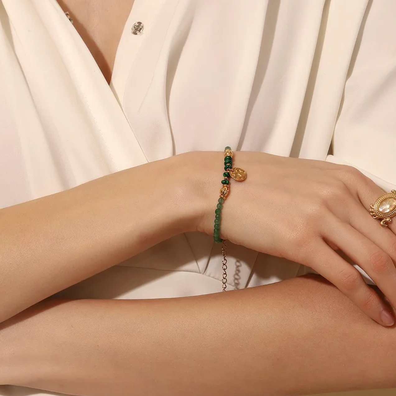 Équilibre parfait entre inspiration naturelle et élégance dorée, ce bracelet en pierre verte type malachite offre une touche mystique et féminine. Le pendentif rond martelé, suspendu au centre, capte la lumière et accentue l’énergie organique du bijou.

Les perles vert profond strié effet malachite évoquent l’ancrage et la stabilité, tandis que les finitions couleur or assurent un rendu sophistiqué et lumineux. Un bijou idéal pour les esprits libres et raffinés.