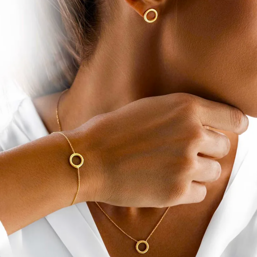 Minimaliste et élégant, ce bracelet couleur or capture l'essence de la discrétion raffinée. L’anneau central, orné d’un motif torsadé, attire subtilement la lumière, ajoutant une note contemporaine à un design classique.

Confectionné en acier inoxydable de qualité, il résiste parfaitement à l’usure du quotidien tout en conservant son éclat. La chaînette réglable assure un ajustement précis et confortable, que ce soit pour un poignet fin ou standard.

À porter seul pour un look épuré, ou en accumulation pou