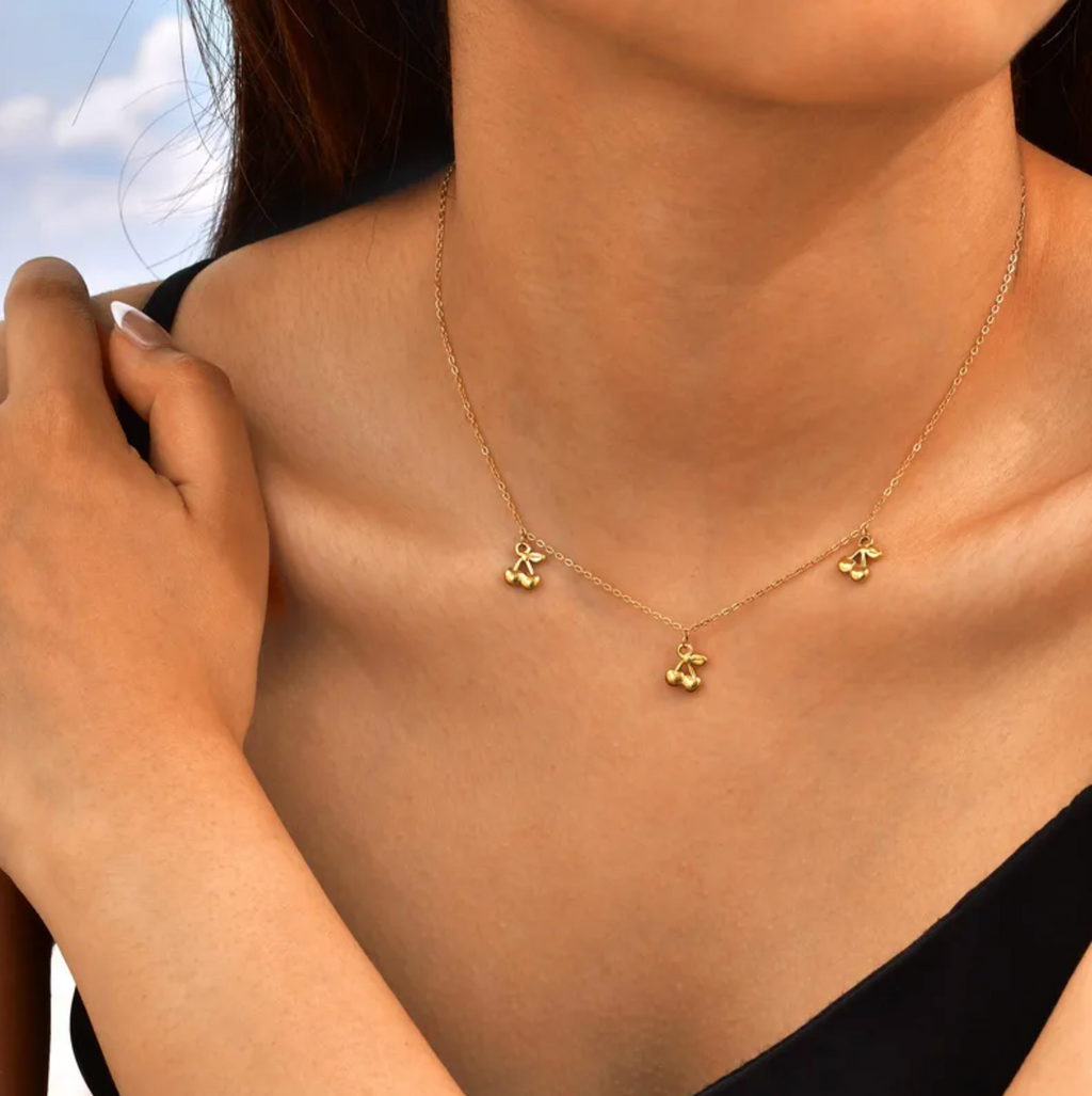 Ce collier en acier inoxydable doré, orné de trois pendentifs en forme de cerises stylisées, est une touche gourmande et espiègle à ajouter à votre tenue. Léger, raffiné, et joyeux, il séduit par son charme minimaliste et original.

Matériau : Acier inoxydable couleur doré, placage PVD or 18K, hypoallergénique, résistant à l’eau et à l’oxydation.