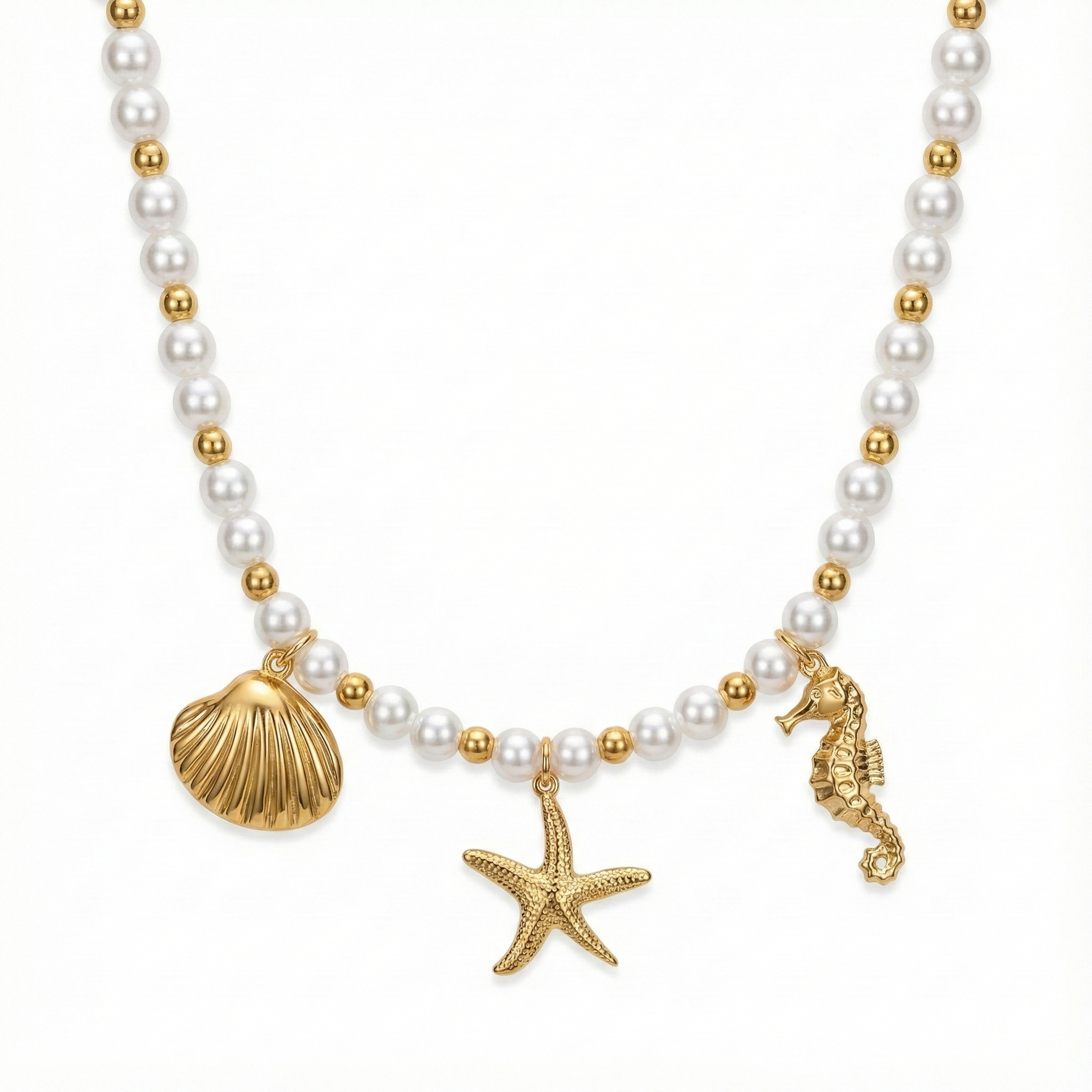 Collier tendance à charms marins : accumulation de breloques coquillages, étoiles de mer et perles sur chaîne dorée.