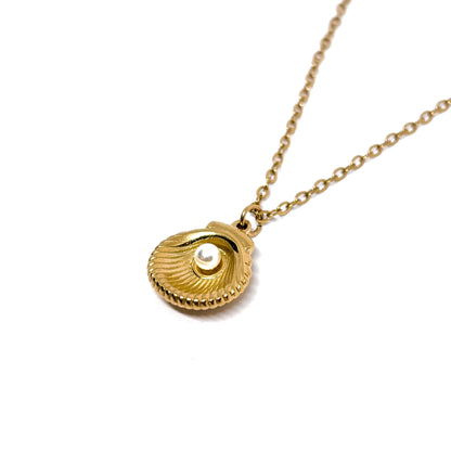 Collier coquillage doré pour femme en acier inoxydable, orné d’une perle blanche imitation nacre au centre du pendentif. Bijou estival et féminin au style bohème chic, résistant à l’eau et lumineux, idéal pour un look marin et raffiné