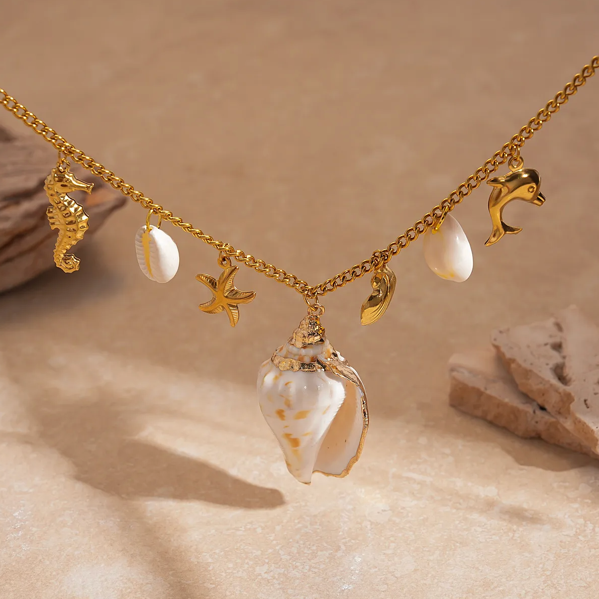 Un collier doré inspiration bord de mer pour habiller vos tenues estivales. Ce bijou aux accents marins associe un coquillage naturel, des pendentifs en forme d’étoile de mer, dauphin et hippocampe, le tout monté sur une chaîne en acier titane hypoallergénique. La brillance dorée contraste élégamment avec les touches nacrées des éléments naturels.

Matériaux : Acier titane, coquillage, résine
Longueur : 47 cm + chaîne d’extension 7 cm
Poids : 23,5 g
Style : Bohème bord de mer, vacances, statement piece