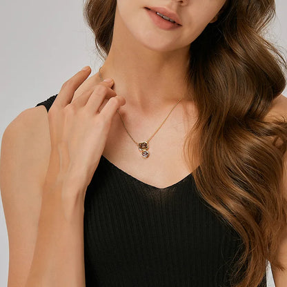 Collier doré pour femme à double pendentif avec pierres géométriques couleur champagne et lilas, monture en plaqué or brillante. Bijou raffiné et lumineux au design sophistiqué, idéal pour une soirée élégante ou un cadeau chic