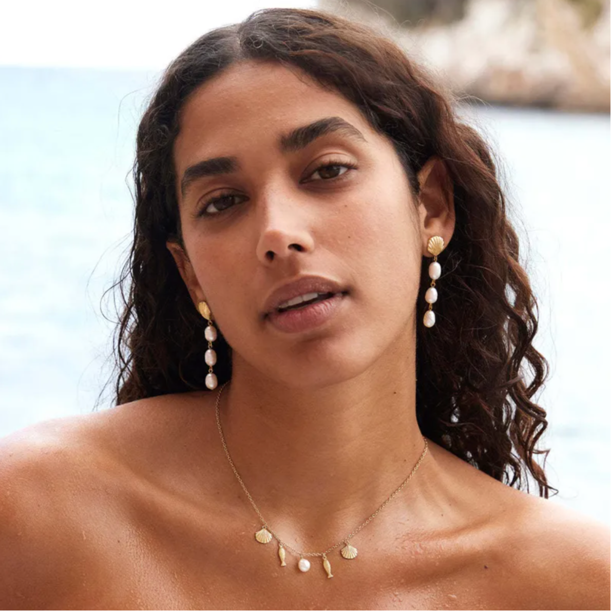 Un collier délicat aux inspirations marines, ponctué de breloques coquillages, poissons gravés et d’une perle blanche centrale, pour une touche estivale chic et légère.

Matériau : Acier inoxydable couleur doré, perle synthétique blanche, résistant à l’eau et à l’oxydation, hypoallergénique.

Dimensions : Longueur 40 + 5 cm, breloques de 8 à 20 mm – léger et confortable au quotidien.

Design : Composition équilibrée autour d’une chaîne fine, alternant formes marines et perle centrale pour un effet doux, har