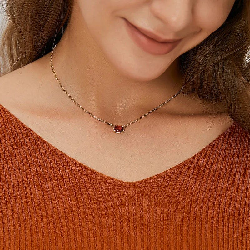 Ce collier fin doré met en valeur une pierre rouge ovale taille facettée, délicatement sertie dans un cadre lisse couleur or. La profondeur vibrante de la pierre évoque la passion et la force intérieure, apportant une touche de charisme sophistiqué à l’ensemble.