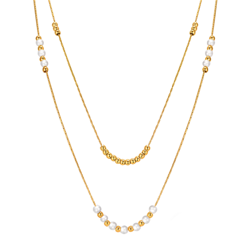 Un collier double rang délicat et lumineux, associant perles blanches nacrées et petites billes dorées, pour un rendu à la fois frais, minimaliste et raffiné.

Matériau : Acier inoxydable couleur doré, perles synthétiques, hypoallergénique, résistant à l’eau et à l’oxydation.

Dimensions : Longueurs des chaînes 37 cm et 44 cm + 5 cm d’extension. Diamètre des perles : 0,4 cm. Poids : 6 g.

Design : Composition équilibrée avec alternance de textures lisses et de reflets nacrés. Superposition fine pour un effe