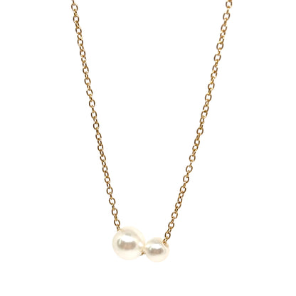 collier femme en acier inoxydable doré avec deux perles blanches nacrées de tailles différentes montées côte à côte sur une chaîne fine, bijou minimaliste et élégant symbolisant l’équilibre et la complicité