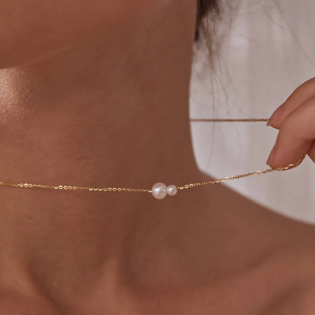 collier femme en acier inoxydable doré avec deux perles blanches nacrées de tailles différentes montées côte à côte sur une chaîne fine, bijou minimaliste et élégant symbolisant l’équilibre et la complicité