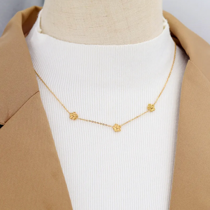 collier femme en acier inoxydable doré composé de trois fleurs miniatures en relief sur une chaîne fine, longueur 40 +5 cm, bijou floral délicat et bohème pour un look romantique et estival