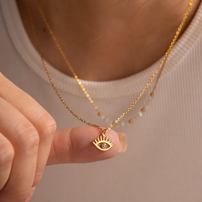 collier femme en acier inoxydable doré à double chaîne avec perles blanches et dorées et pendentif œil protecteur serti d’un strass, longueurs 39 et 41 +4 cm, bijou boho chic et symbolique