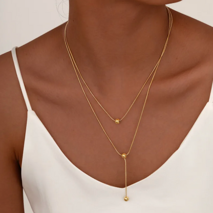 collier femme double rang en acier inoxydable doré avec deux perles sphériques et pendentif vertical, longueur 38 et 45,5 +5 cm, bijou minimaliste et élégant au style contemporain
