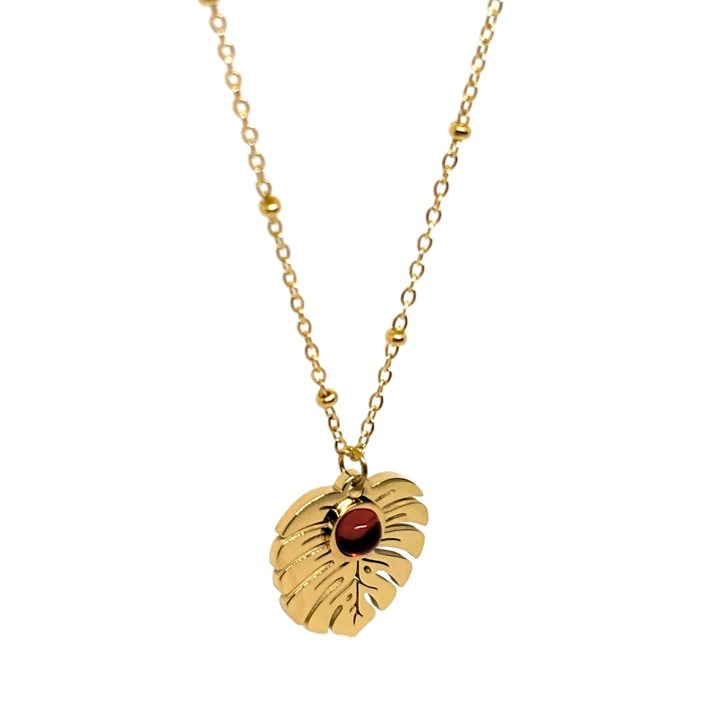 collier femme en acier inoxydable doré avec pendentif feuille Monstera orné d’une pierre rouge centrale, longueur 40 +5 cm, bijou végétal lumineux au style nature chic et estival