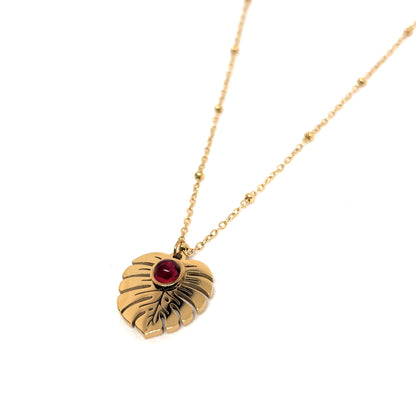 collier femme en acier inoxydable doré avec pendentif feuille Monstera orné d’une pierre rouge centrale, longueur 40 +5 cm, bijou végétal lumineux au style nature chic et estival