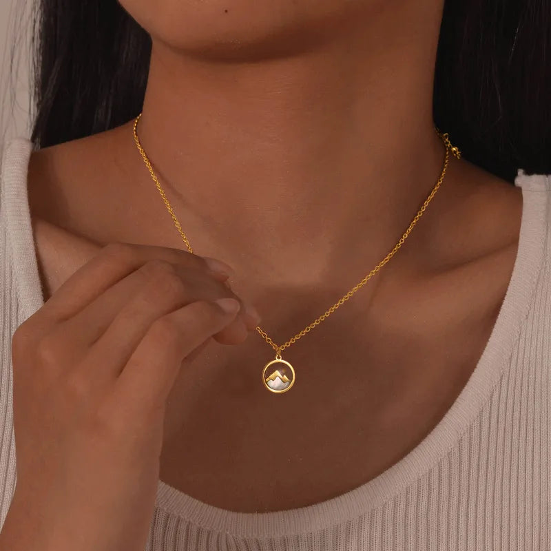 collier femme en acier inoxydable doré avec médaillon rond représentant un paysage de montagne sur fond nacré, longueur 45 à 50 cm, bijou poétique et discret inspiré de la nature