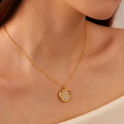 Collier doré pour femme en acier inoxydable avec médaillon rond transparent renfermant un arbre de vie doré et des éclats de cristal. Bijou lumineux et spirituel, résistant à l’eau et hypoallergénique, symbole d’harmonie et de croissance intérieure