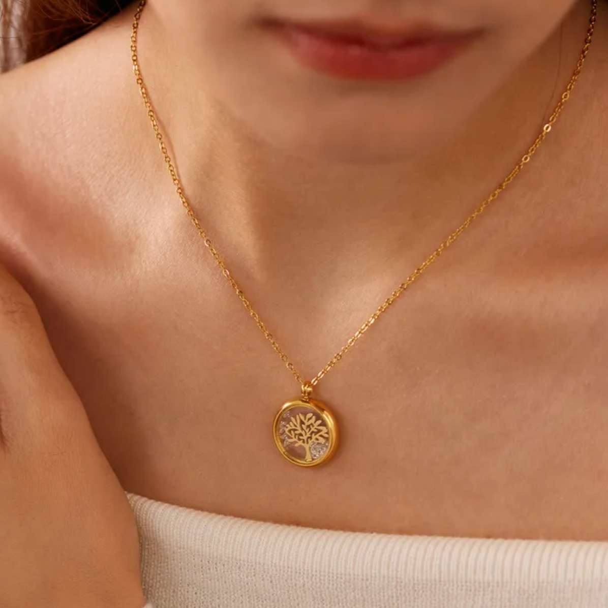 Collier doré pour femme en acier inoxydable avec médaillon rond transparent renfermant un arbre de vie doré et des éclats de cristal. Bijou lumineux et spirituel, résistant à l’eau et hypoallergénique, symbole d’harmonie et de croissance intérieure