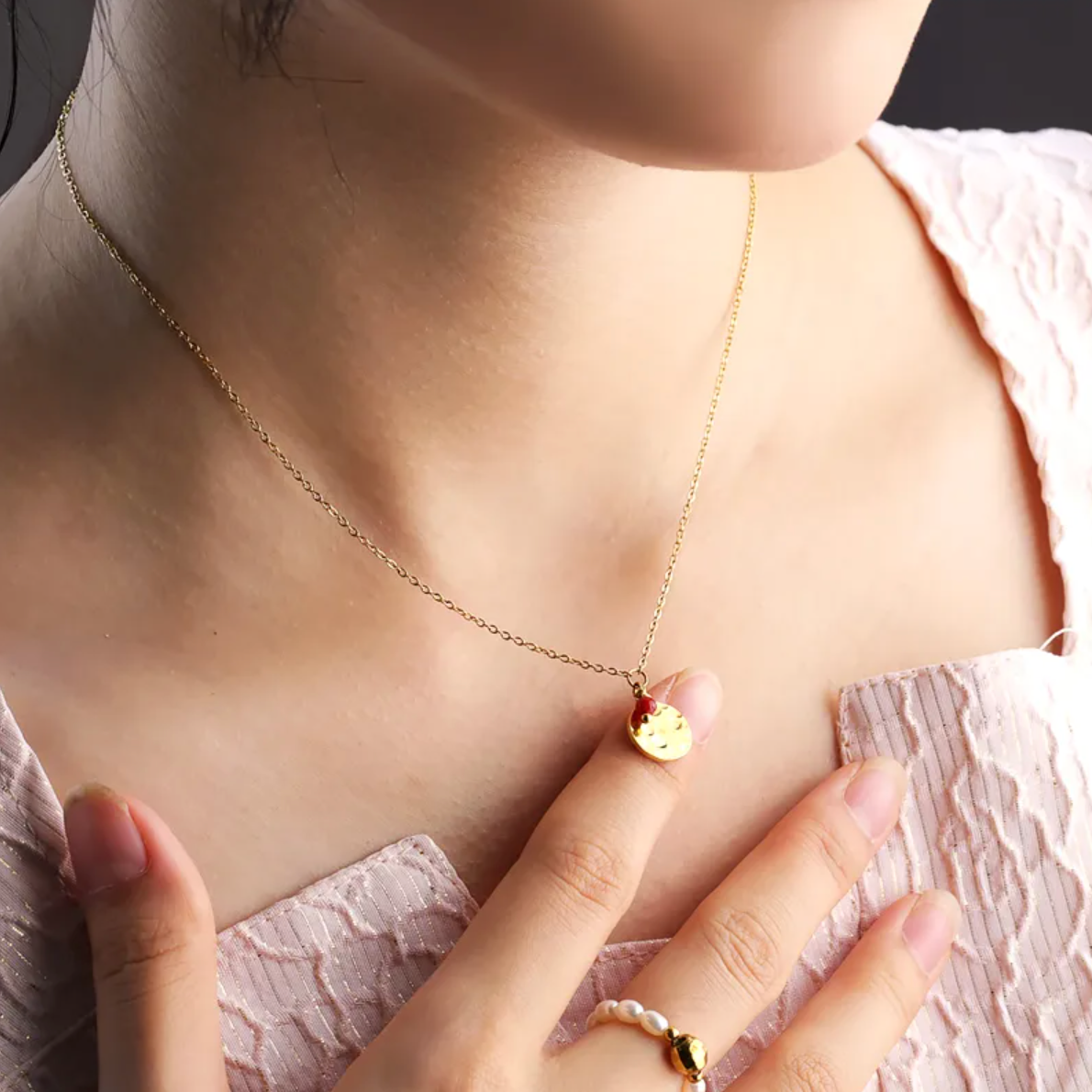 Collier doré pour femme avec médaillon rond martelé façon lune et petite pierre rouge type grenat. Bijou raffiné en acier inoxydable, résistant à l’eau et hypoallergénique, au design poétique et minimaliste