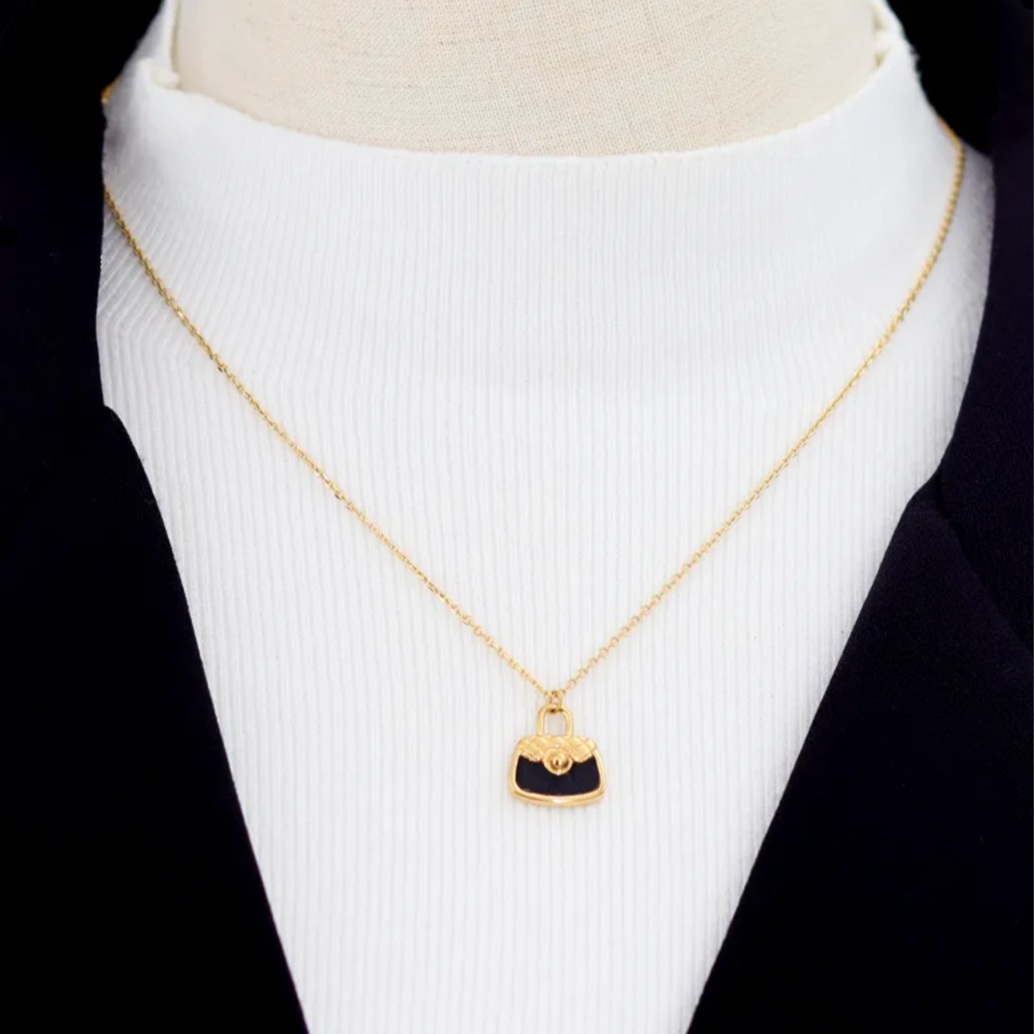 Collier doré pour femme en acier inoxydable avec pendentif en forme de sac à main noir émaillé. Bijou original et tendance, résistant à l’eau et hypoallergénique, au style chic et inspiré de la haute couture