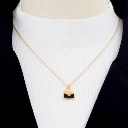Collier doré pour femme en acier inoxydable avec pendentif en forme de sac à main noir émaillé. Bijou original et tendance, résistant à l’eau et hypoallergénique, au style chic et inspiré de la haute couture