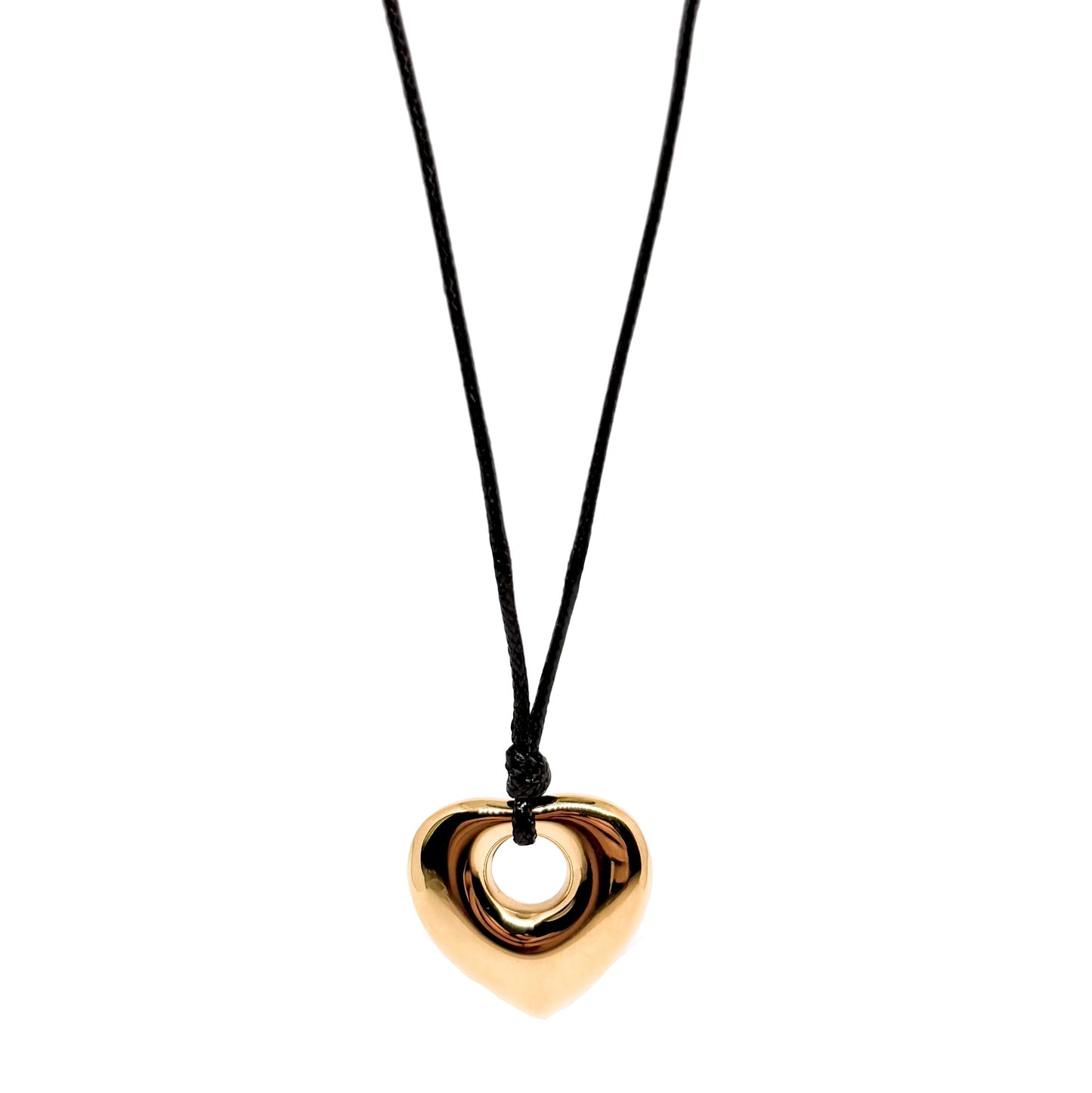 Collier long pour femme avec pendentif cœur doré en acier inoxydable suspendu à un cordon noir. Bijou moderne et graphique, au design massif et miroir, idéal pour un look audacieux et contemporain