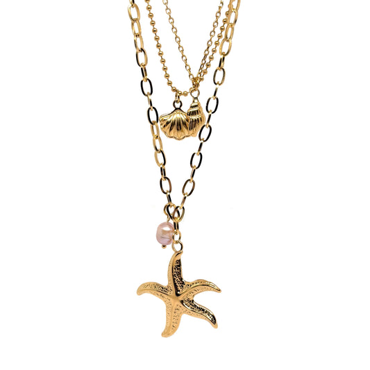 Collier multi-rangs pour femme en acier inoxydable couleur doré, orné de pendentifs coquillage, étoile de mer et perle nacrée. Bijou lumineux et estival au style bohème et marin, parfait pour un look vacances chic