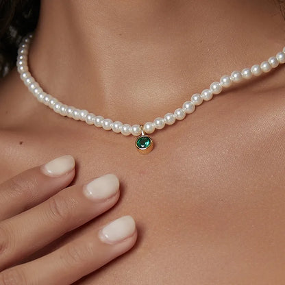 collier femme de perles blanches orné d’un pendentif rond en pierre verte émeraude facettée cerclée de doré, longueur ajustable 40 à 45 cm, bijou intemporel et audacieux au charme élégant