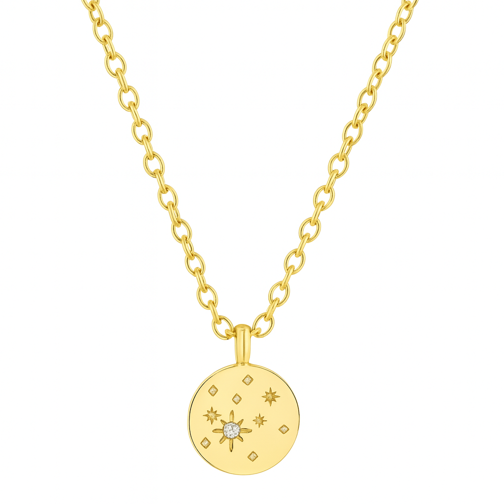 Ce collier doré au médaillon gravé d’étoiles est un véritable hommage à l’univers céleste. En son centre, une étoile du nord incrustée d’un zircon blanc scintillant guide le regard, entourée d’un motif de constellations gravées avec finesse. Une pièce à la fois poétique et intemporelle, symbole de lumière intérieure et de guidance.

Réalisé en laiton plaqué or, ce bijou allie douce brillance, finesse de gravure, et léger relief pour un rendu chic et discret. Il se porte aussi bien au quotidien qu’en touche 