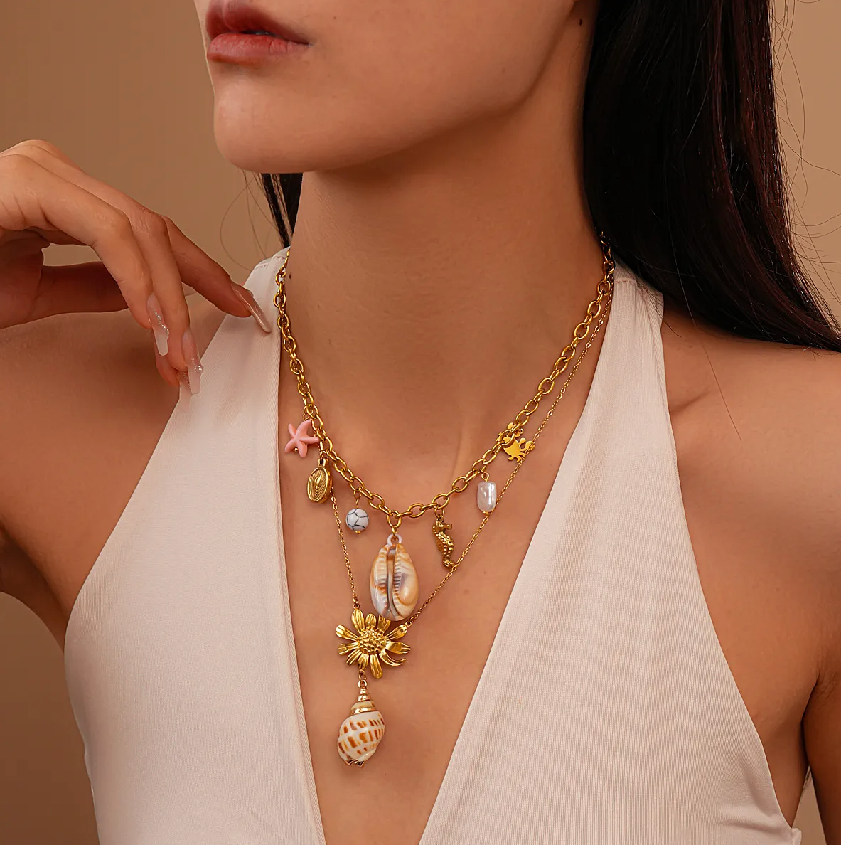 Un collier solaire et organique, associant une fleur dorée texturée à un véritable coquillage, pour un look bohème chic aux accents marins.

Matériau : Acier titane couleur doré, coquillage naturel – hypoallergénique et résistant à l’eau.

Dimensions : Longueur totale 49,5 cm + chaîne d’extension 8 cm – poids léger : 6,5 g.

Design : La fleur centrale aux pétales sculptés sert de base à un coquillage suspendu, apportant un effet organique et raffiné. Finition soignée.

Style : Parfait pour l’été, les tenues