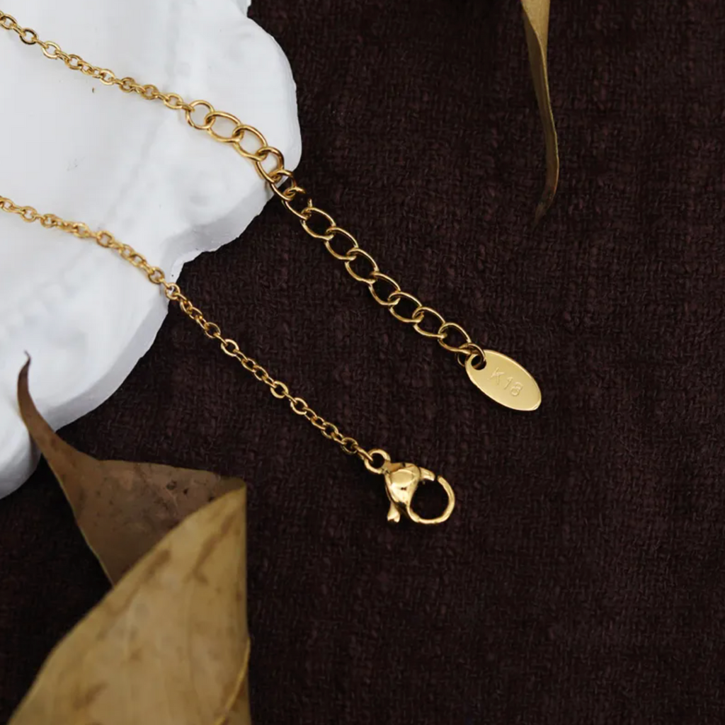 Évoquant une carte céleste ancienne, ce collier doré orné d'une médaille martelée met en valeur une étoile du Nord en relief, symbole de repère et de guidance. Le contraste entre les textures brutes et le poli du motif central donne une pièce forte, authentique et pleine de caractère.

Matériaux : Acier titane, finition couleur or
Dimensions : pendentif 1,5 cm x 1 cm – chaîne 40 + 5 cm
Style : Astrologique, médaillon vintage, symbolique