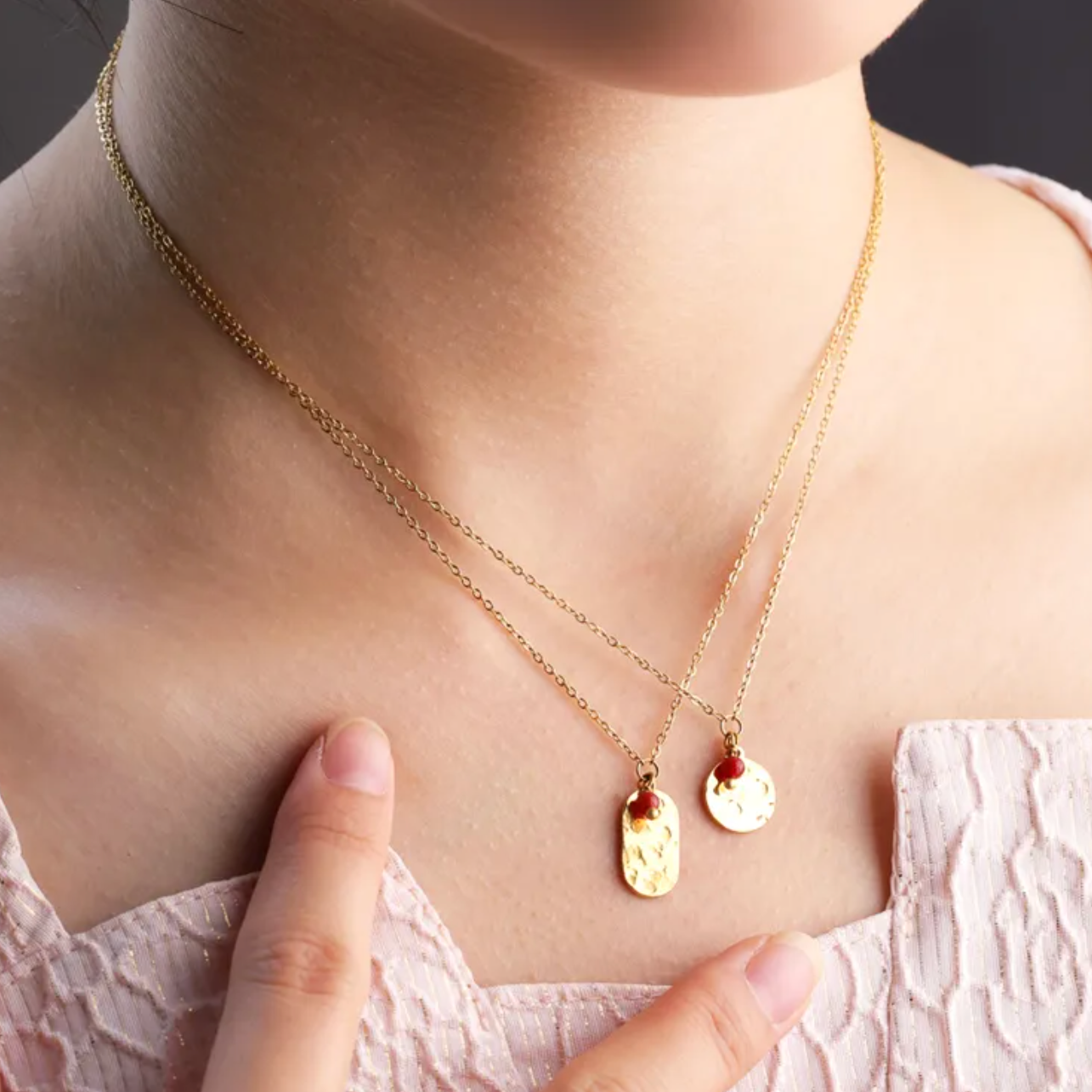 Ce collier doré révèle un pendentif rectangulaire martelé orné d’une perle rouge cerise. Une pièce simple mais pleine de caractère.

Matériaux : Acier inoxydable doré – résistant à l’eau, hypoallergénique, finition martelée pour un effet texturé chic.

Dimensions : Longueur 40 + 5 cm – pendentif 15 mm x 8 mm – poids ≈ 2,5 g.

Style : Minimaliste et moderne, ce bijou apporte une touche de chaleur et d’originalité. Idéal pour un look quotidien ou un cadeau raffiné.