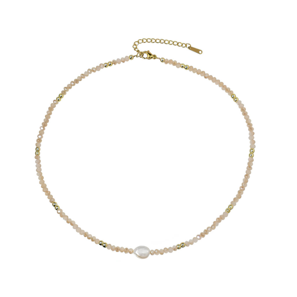 Un collier fin et délicat, composé de perles beige nude, de cristaux dorés, et d’une perle blanche d’eau douce centrale. L’association parfaite entre légèreté, douceur et sophistication discrète.

Matériau : Acier inoxydable couleur doré (316L), cristal, perles synthétiques + perle d’eau douce centrale, hypoallergénique, résistant à l’eau et à l’oxydation.

Dimensions : Longueur 40 cm + 5 cm de rallonge – fermoir mousqueton doré sécurisé.

Design : Enfilade de perles facettées beige rosé, rythmée par de min