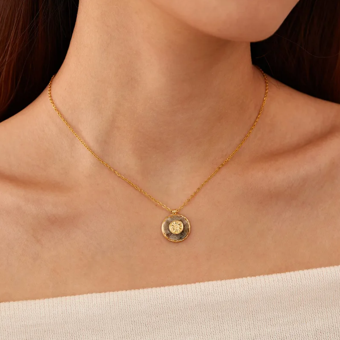 Un collier délicat orné d’un médaillon circulaire en pierre naturelle, sublimé d’un motif rosace central doré. Une pièce à l’énergie douce et spirituelle, entre nature brute et géométrie sacrée.

Matériau : Acier inoxydable couleur doré, pierre naturelle centrale. Résiste à l’eau, hypoallergénique, durable.

Dimensions : Longueur chaîne 40 cm + 6 cm d’extension. Médaillon : 18 mm x 15,7 mm. Poids : 4 g – discret, très léger.

Design : Médaillon rond en pierre naturelle sertie, avec une rosace stylisée en re