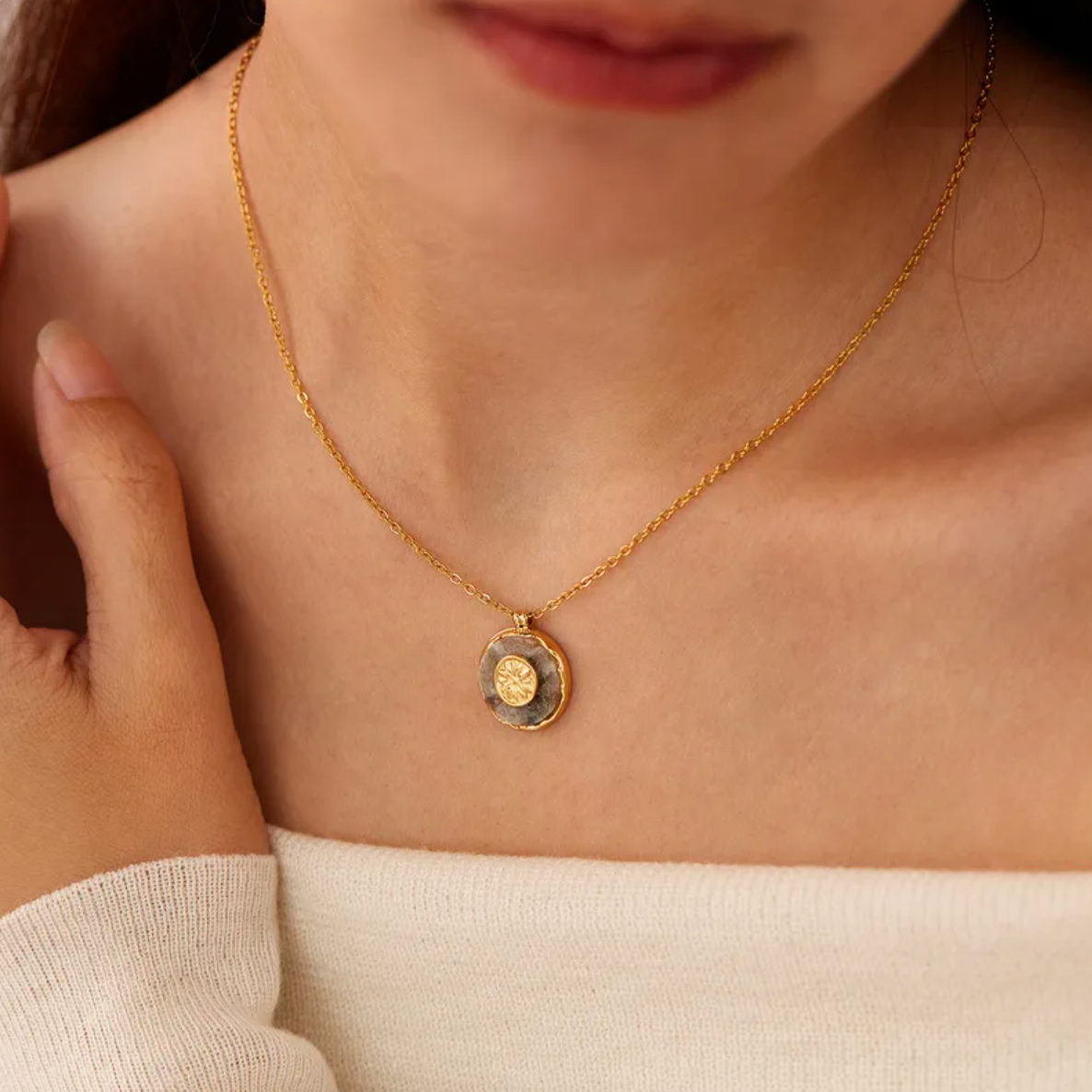 Un collier délicat orné d’un médaillon circulaire en pierre naturelle, sublimé d’un motif rosace central doré. Une pièce à l’énergie douce et spirituelle, entre nature brute et géométrie sacrée.

Matériau : Acier inoxydable couleur doré, pierre naturelle centrale. Résiste à l’eau, hypoallergénique, durable.

Dimensions : Longueur chaîne 40 cm + 6 cm d’extension. Médaillon : 18 mm x 15,7 mm. Poids : 4 g – discret, très léger.

Design : Médaillon rond en pierre naturelle sertie, avec une rosace stylisée en re