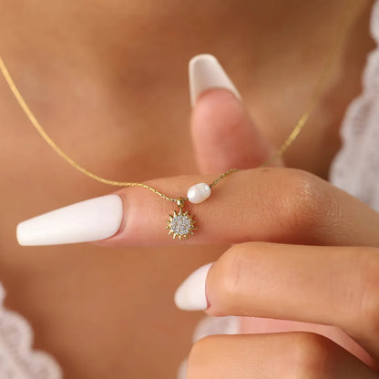 Collier couleur or en acier inoxydable avec pendentif soleil serti de zircons et perle blanche, chaîne fine ajustable pour femme.
