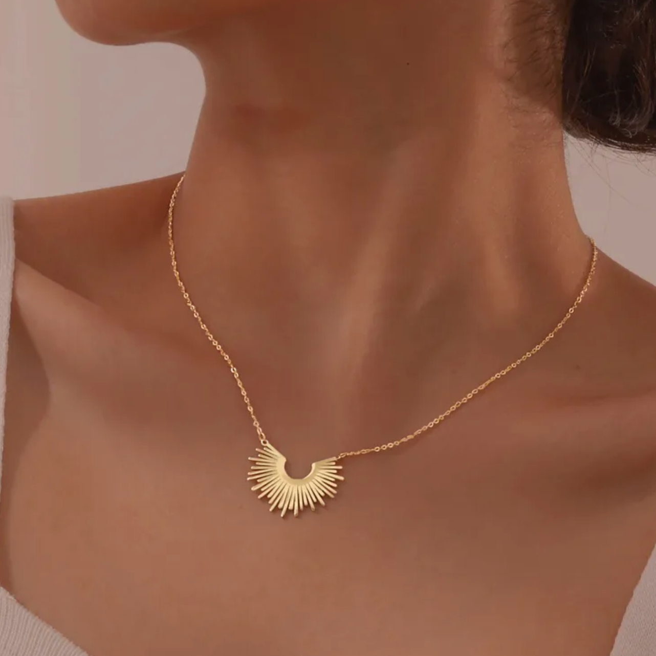 Un collier doré tendance orné d’un pendentif en forme de soleil stylisé, à la silhouette graphique et épurée. Un bijou lumineux au design solaire qui attire le regard avec élégance.

Matériau : Acier inoxydable couleur doré, finition brillante, hypoallergénique, résistant à l’eau et à la transpiration.

Dimensions : Longueur chaîne 41 à 46 cm – pendentif 2,7 cm x 2,1 cm – poids léger de 4 g.

Design : Motif rayonnant découpé avec finesse, monté sur une chaîne à maillons fins. Fermoir classique discret.

Sty