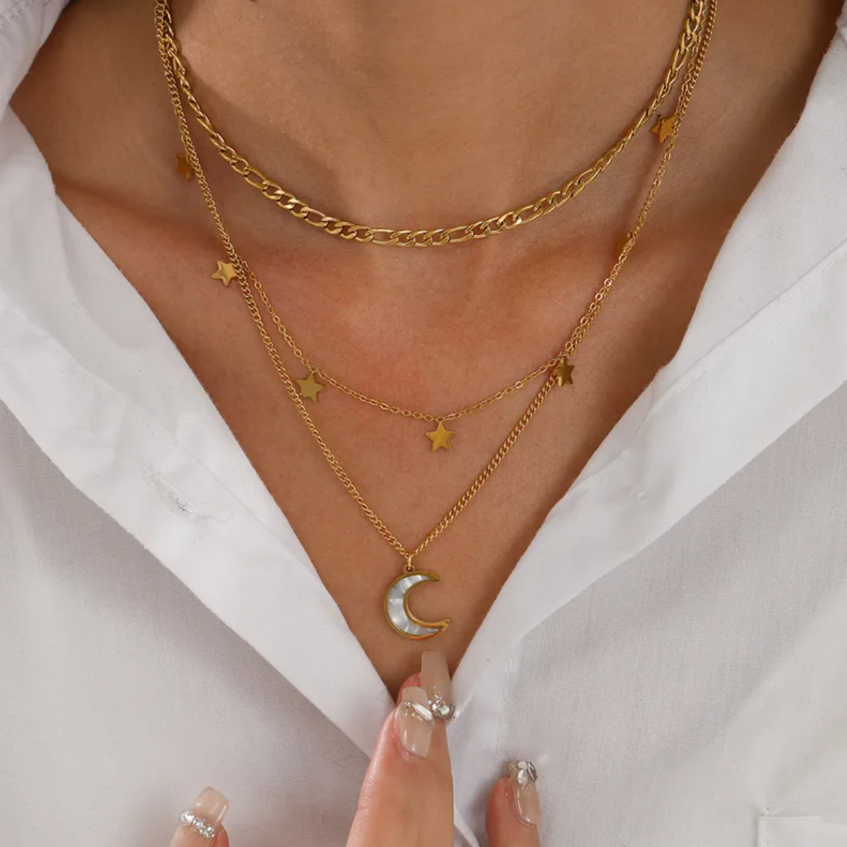 Composé de trois chaînes délicatement agencées, ce collier superposé doré conjugue puissance symbolique et esthétique céleste. Une lune nacrée suspendue au rang le plus long dialogue avec des étoiles dorées dispersées sur les deux autres chaînes, pour un rendu poétique, féminin et captivant.

Matériaux : Acier inoxydable, finition couleur or
Dimensions : 37 + 5 cm, 41 + 5 cm, 45 + 5 cm – pendentif lune : 1,5 cm – étoiles : 6 mm
Style : Astral, superposé, féminin bohème