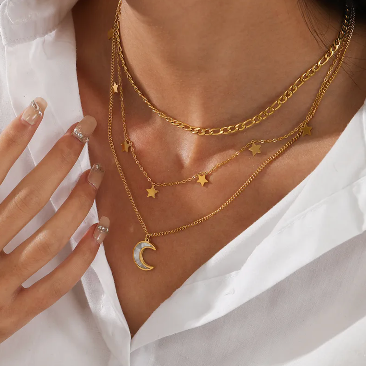 Composé de trois chaînes délicatement agencées, ce collier superposé doré conjugue puissance symbolique et esthétique céleste. Une lune nacrée suspendue au rang le plus long dialogue avec des étoiles dorées dispersées sur les deux autres chaînes, pour un rendu poétique, féminin et captivant.

Matériaux : Acier inoxydable, finition couleur or
Dimensions : 37 + 5 cm, 41 + 5 cm, 45 + 5 cm – pendentif lune : 1,5 cm – étoiles : 6 mm
Style : Astral, superposé, féminin bohème